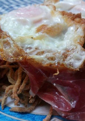 Una foto de Huevos rotos con jamón sobre chanquetes de pobre (gulas)