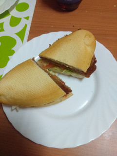 Una foto de Bocadillo de ternera empanada con tomate, escarola y mayonesa