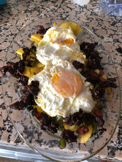 Una foto de Huevos con patatas pimientos, ajo, cebolla y trocitos de morcilla y chorizo