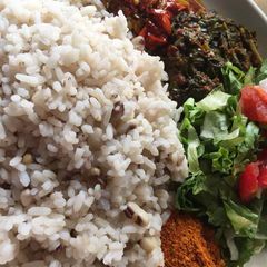 A picture of Rice and beans with stew and salad.