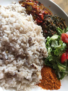 A picture of Rice and beans with stew and salad.