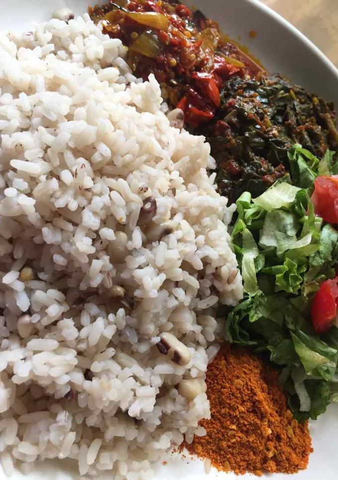 A picture of Rice and beans with stew and salad.