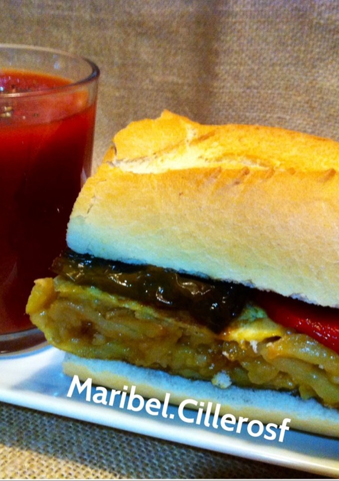 Una foto de Bocadillo de tortilla Española con pimientos fritos+Zumo de tomate