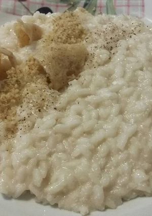 Foto di Risotto al parmigiano, con noci, pepe e cialde di grana