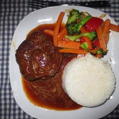 A picture of Beef Stew served with Rice and assorted vegetables.