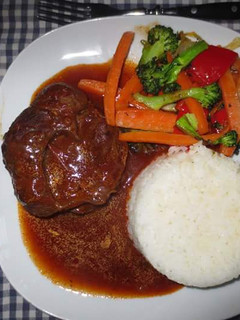 A picture of Beef Stew served with Rice and assorted vegetables.