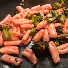 A picture of Pink pasta with sprouting broccoli and anchovies.