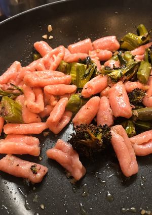 A picture of Pink pasta with sprouting broccoli and anchovies.