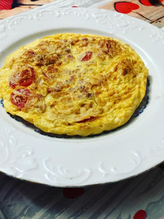 Una foto de Tortilla de tomate cherry y taquitos de jamón