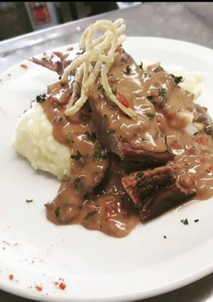 Una foto de Ternera en reducción de Malbec, salsa de hongos y puré de papas