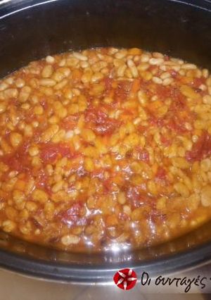 A picture of Beans in the oven with peppers and olives.