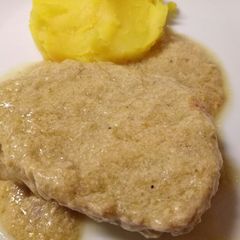 A picture of Pork in a creamy artichoke sauce with saffron mash.