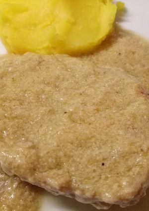 A picture of Pork in a creamy artichoke sauce with saffron mash.