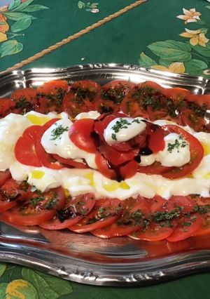 Une photo de Salade de tomates roses à la mozzarella di buffala, persil et crème de balsamique