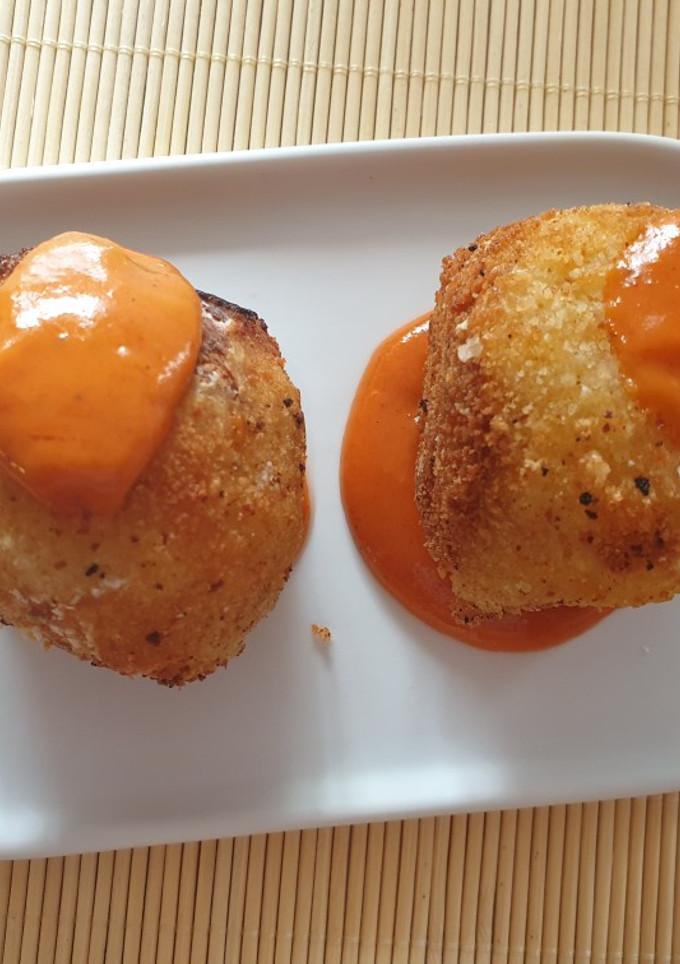 Una foto de Bombas de patatas rellenas de carne con salsa brava