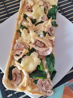 Una foto de Pizza de pollo, espinaca y champiñones