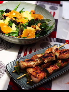 Una foto de Brochetas de pollo adobadas con ensalada variada de manzana, naranja, anacardos y pasas