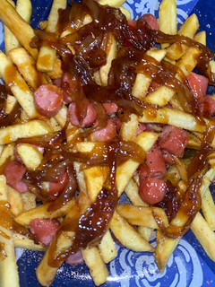 Una foto de Salchipapas con cebolla caramelizada