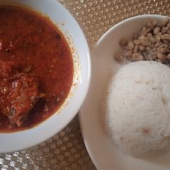 A picture of White rice, beans with dried fish stew.