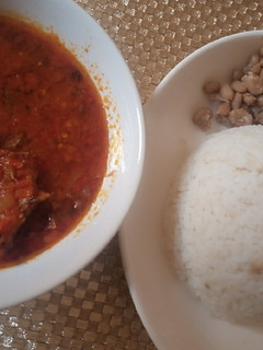 A picture of White rice, beans with dried fish stew.