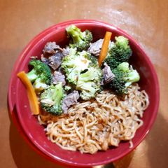 A picture of Noodles served with brocolli.