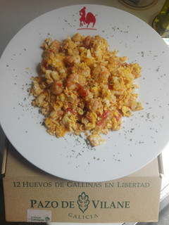 Una foto de Huevos rotos de gambas al ajillo