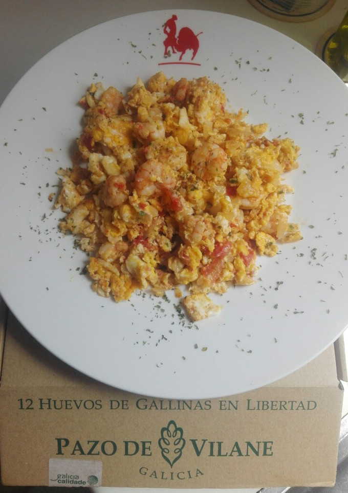 Una foto de Huevos rotos de gambas al ajillo