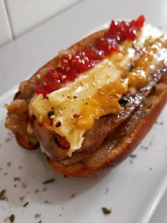 Una foto de Brioche de butifarra y brie con mermelada de tomate y cebolla