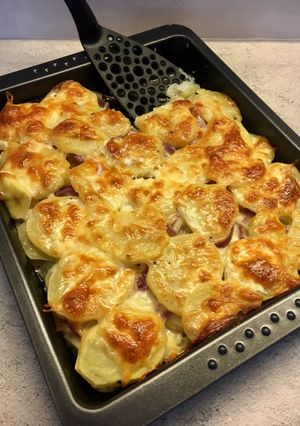 Sütőben sült hagymás krumpli sok sajttal: krémes és pikáns recept fotója