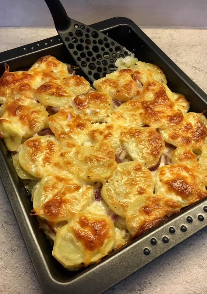 Sütőben sült hagymás krumpli sok sajttal: krémes és pikáns recept fotója