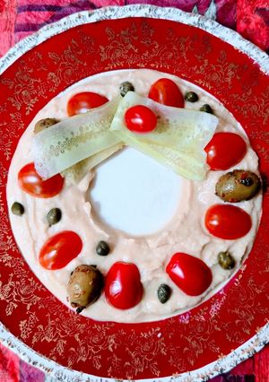 Una foto de Corona navideña express de hummus 🎄Hummus decorado con tomatitos, olivas, pepino y alcaparras 🎄