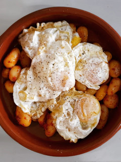 Una foto de Huevos rotos con patatas al ajo escalivado y sobrasada