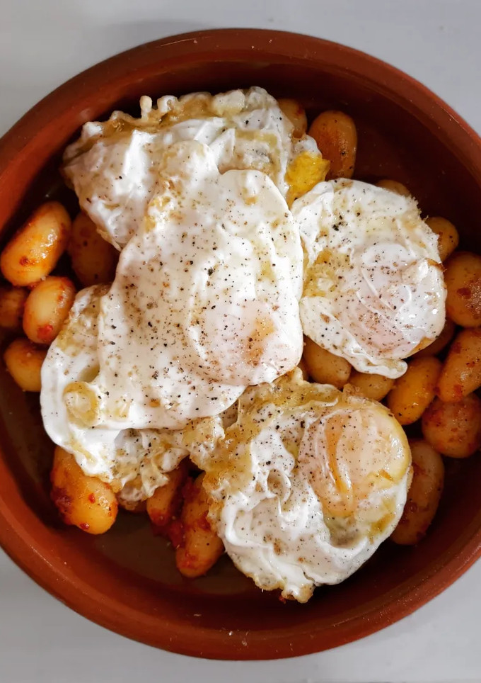 Una foto de Huevos rotos con patatas al ajo escalivado y sobrasada