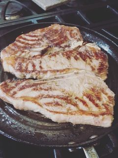A picture of New York Strip SteaksWith A1 steak sauce and Siracha.
