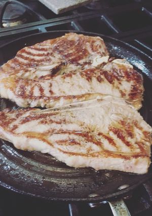 A picture of New York Strip SteaksWith A1 steak sauce and Siracha.