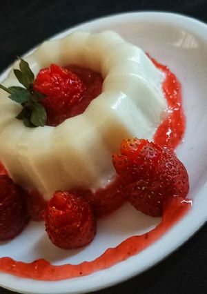 Una foto de Panna cotta de coco con cuolis de fresa
