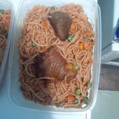 A picture of Spaghetti with chicken carrots and green peas.