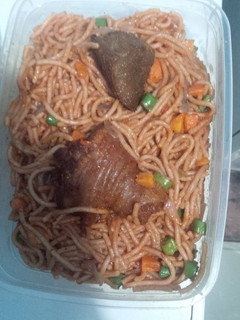 A picture of Spaghetti with chicken carrots and green peas.