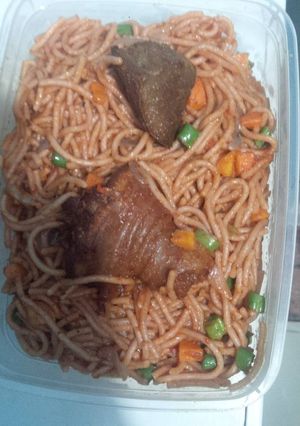A picture of Spaghetti with chicken carrots and green peas.