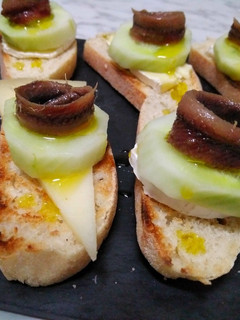 Una foto de Tostaditas de quesos con pepino y anchoas