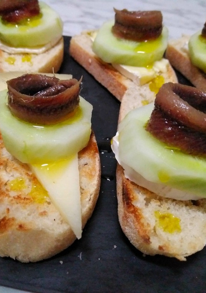 Una foto de Tostaditas de quesos con pepino y anchoas