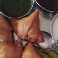 A picture of Samosa with chutney.