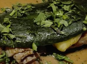 Una foto de Chile relleno de cecina con queso en salsa de frijol