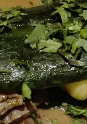 Una foto de Chile relleno de cecina con queso en salsa de frijol