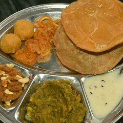 A picture of Dry aalu sabzi with crispy kachori.
