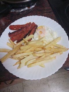 Una foto de Papas fritas con huevo frito y chorizo