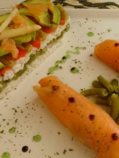 Una foto de Timbal de arroz y verduras con rollitos de salmon ahumado