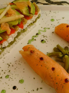 Una foto de Timbal de arroz y verduras con rollitos de salmon ahumado