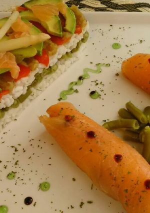 Una foto de Timbal de arroz y verduras con rollitos de salmon ahumado 