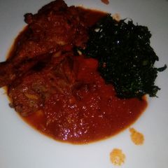 A picture of Chicken in gravy sauce and pan-fried kales.
